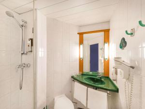 a bathroom with a sink, toilet and shower at Ibis Praha Mala Strana in Prague