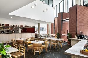 a restaurant with tables and chairs and a kitchen at Veriu Green Square in Sydney