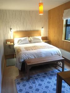 a bedroom with a large bed with a wooden headboard at Hotel Ilaia in Punta Arenas