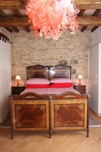 a bedroom with a bed with red pillows and a chandelier at B&B Cal Torello in Urbino