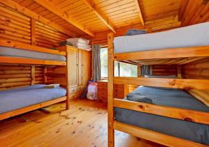 Cloudy Bay Cabin في South Bruny: غرفة نوم مع سريرين بطابقين في كابينة خشب