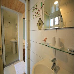 La salle de bains est pourvue d'un lavabo et d'un miroir. dans l'établissement Sky Island B&B, à Jiaoxi
