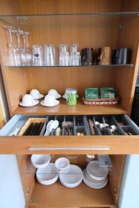 a cupboard filled with white plates and dishes at Yoshimura Tenjoan in Fujikawaguchiko