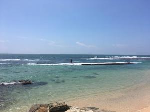Malee Villa (Beach Inns Holiday Resort) في ماتارا: شخص يقف في الماء عند الشاطئ