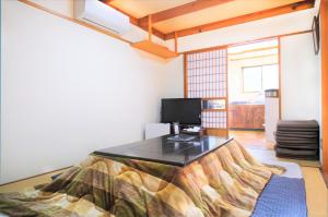 Una habitación con una cama con una mesa. en Yoshimura Tenjoan en Fujikawaguchiko