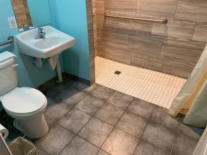 a bathroom with a toilet and a sink and a shower at Delux Inn in Clearwater