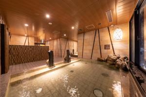 Dormy Inn Mito في ميتو: حمام كبير مع حوض استحمام ساخن في الغرفة