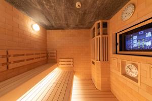Dormy Inn Mito في ميتو: غرفة بها تلفزيون وغرفة بها ساعات
