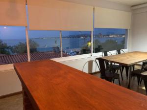 un comedor con 2 mesas y una ventana grande en Vistas al mar piriapolis, en Piriápolis