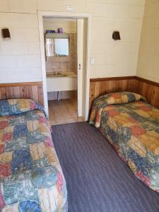 ein Schlafzimmer mit 2 Betten und ein Badezimmer in der Unterkunft Opal Inn Hotel, Motel, Caravan Park in Coober Pedy