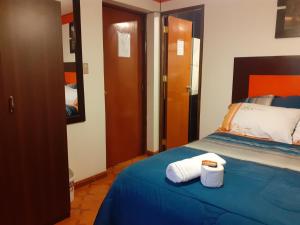a bedroom with a bed with two towels on it at Amaru Hotel Huaraz in Huaraz