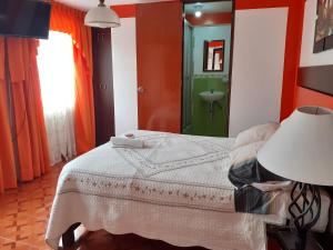 a bedroom with a bed with a lamp and a sink at Amaru Hotel Huaraz in Huaraz