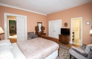 a bedroom with a bed and a television in it at Looking Glass Inn in Indianapolis