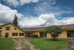 a yellow house with a tree in the yard at FUENTE FLORES -Casa de campo- in Iza