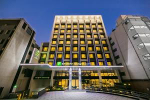 a building with a lit up front of it at Holiday Inn Express Taichung Fengchia, an IHG Hotel in Taichung