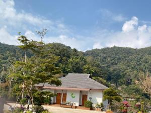 een huis met een berg op de achtergrond bij Thai Tea Garden Home in Chiang Rai