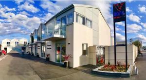 a white building with a sign in front of it at V Motel in Christchurch