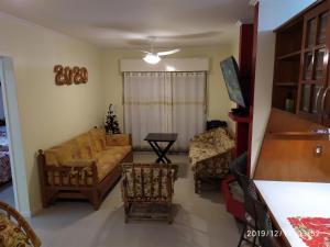 sala de estar con sofá y 2 sillas en Apartamento Capão Novo, en Capão da Canoa
