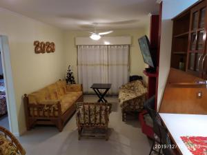 a living room with a couch and two chairs at Apartamento Capão Novo in Capão da Canoa