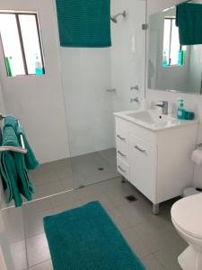 
a bathroom with a toilet, sink, and shower at Lazy Dayz Shellharbour in Shellharbour

