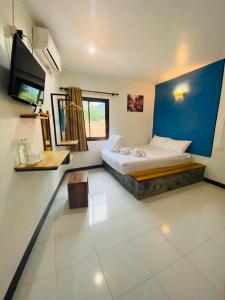 1 dormitorio con cama y pared azul en The Stamp Hotel en Ko Tao