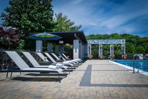 a row of white lounge chairs next to a pool at Hotel Indigo East End, an IHG Hotel in Riverhead