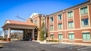un grand bâtiment en briques rouges avec un parking dans l'établissement Holiday Inn Express Hotel & Suites Memphis/Germantown, an IHG Hotel, à Memphis