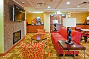 salon z czerwoną kanapą i kominkiem w obiekcie Holiday Inn Express Hotel & Suites Memphis/Germantown, an IHG Hotel w mieście Memphis
