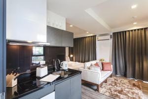 a kitchen and a living room with a couch at The Deck Condominium by Lofty in Patong Beach