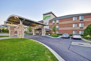 a hotel with cars parked in front of a building at Holiday Inn Express Romulus / Detroit Airport by IHG in Romulus