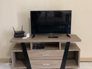 TV en un soporte de madera con TV en Casa De Pedro- Entire Villa en Mangilao