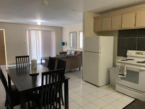 a kitchen and living room with a table and a white refrigerator at Casa De Pedro- Entire Villa in Mangilao