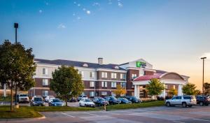 um hotel com carros estacionados num parque de estacionamento em Holiday Inn Express Hotel & Suites Altoona-Des Moines, an IHG Hotel em Altoona