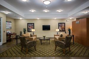 una sala de espera con sofás, sillas y TV en Candlewood Suites Indianapolis Northwest, an IHG Hotel, en Indianápolis