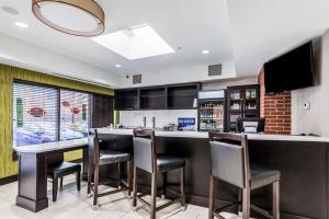 a kitchen with a bar with chairs and a tv at Holiday Inn - Indianapolis Downtown, an IHG Hotel in Indianapolis