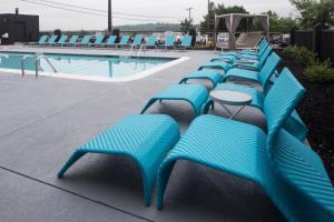 a row of blue benches next to a swimming pool at Hotel Indigo Harrisburg – Hershey in Harrisburg
