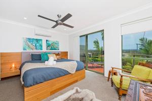Bonny Hills的住宿－Panorama Beach House，一间卧室配有一张带吊扇的床