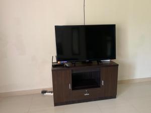 a flat screen tv sitting on a wooden entertainment center at Entire Private Villa- Casa De Pedro in Mangilao