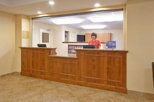 a woman standing at a counter in a library at Candlewood Suites Roswell, an IHG Hotel in Roswell