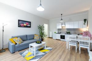 uma sala de estar com um sofá azul e uma cozinha em Lucky Place BASIC em Bielsko-Biala