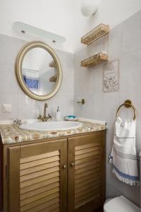ein Bad mit einem Waschbecken und einem Spiegel in der Unterkunft Katoussa in Paleokastritsa
