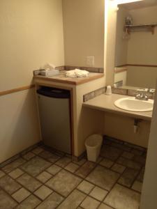 een badkamer met een wastafel en een spiegel bij High Chaparral Inn in Rocky Ford