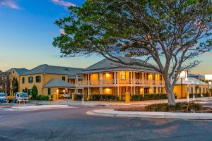 a large building with a tree in front of it at Ballina Heritage Inn in Ballina