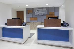 two reception desks in a lobby with a wall at Holiday Inn Express Hotel & Suites Austin Downtown - University, an IHG Hotel in Austin