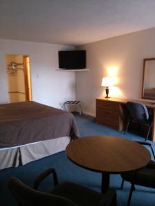 een hotelkamer met een bed en een tafel en stoelen bij High Chaparral Inn in Rocky Ford