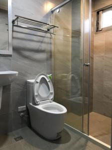 uma casa de banho com um WC e uma cabina de duche em vidro. em JOY Homestay em Shoufeng