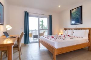 1 dormitorio con cama, escritorio y ventana en Cebu Seaview Dive Resort en Moalboal