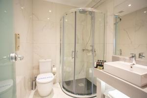 a bathroom with a shower and a toilet and a sink at Rhodos Horizon Blu-Adults Only in Rhodes Town
