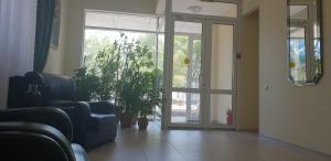 a waiting room with a glass door and a plant at Altyn-Adam Hotel in Astana