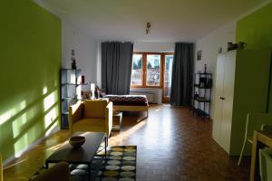 ein Wohnzimmer mit grünen Wänden und gelben Möbeln in der Unterkunft Hindenburg str Apartments in Garmisch-Partenkirchen